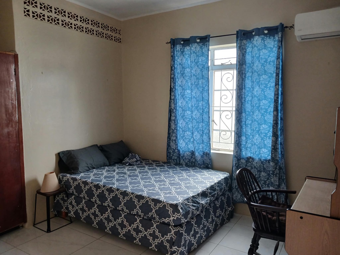 Bedroom two with double bed, blue floral curtains and rocking chair