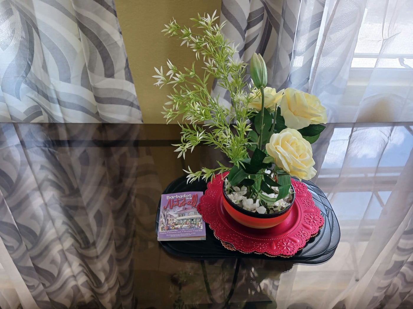 Roses and the Barbados in a Nutshell guide on the glass side table